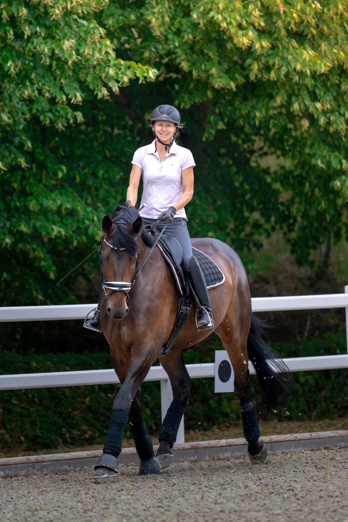 Carolin Hornkohl auf einem braunen Pferd im Dressurviereck der Reitanlage